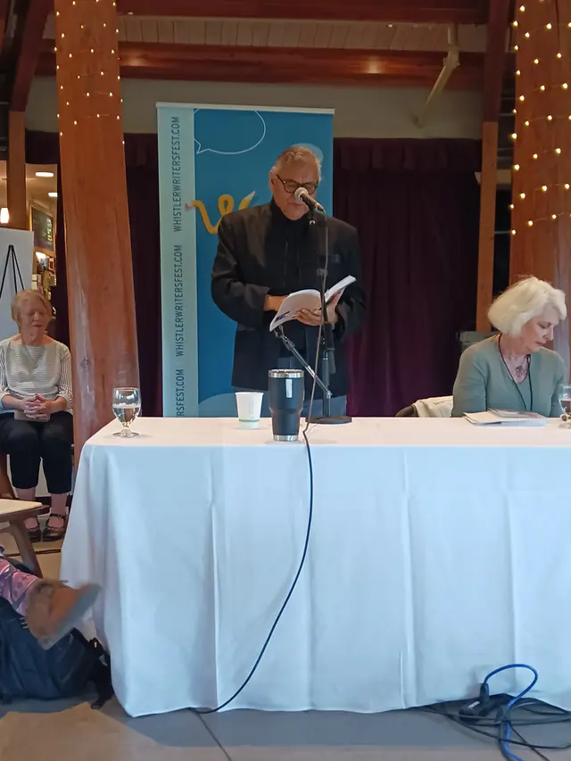 William reading from a lectern at the Whistler Writers Festival